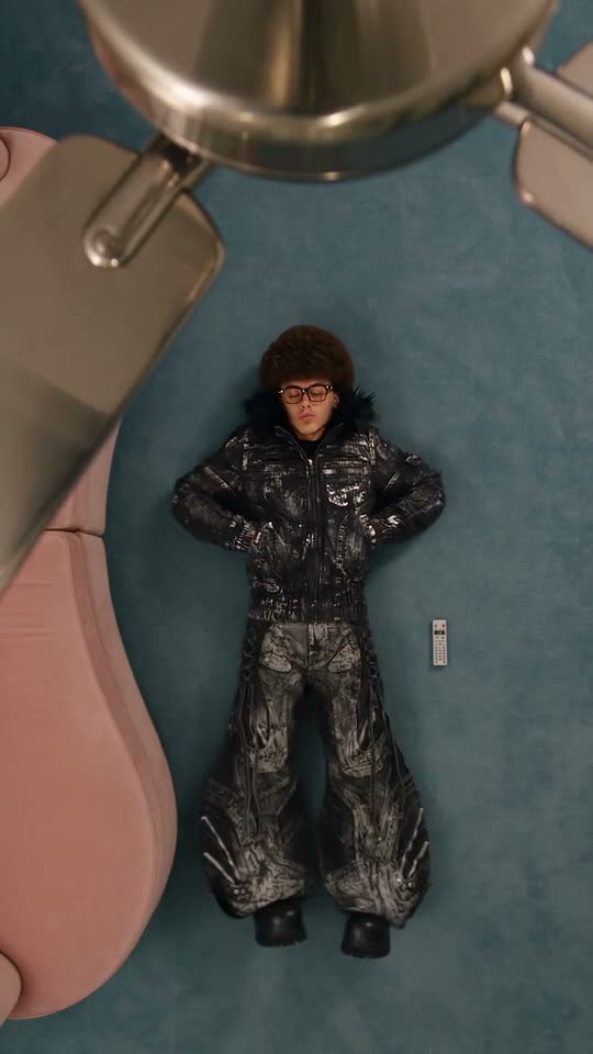 Ceiling fan transition: a young man on a teal carpet switches between four streetwear fits under the fan