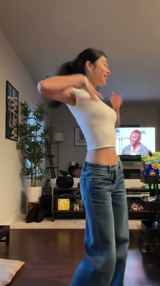 Nicole Kidman dance: a young woman in a white top and jeans does the dance alone in her living room