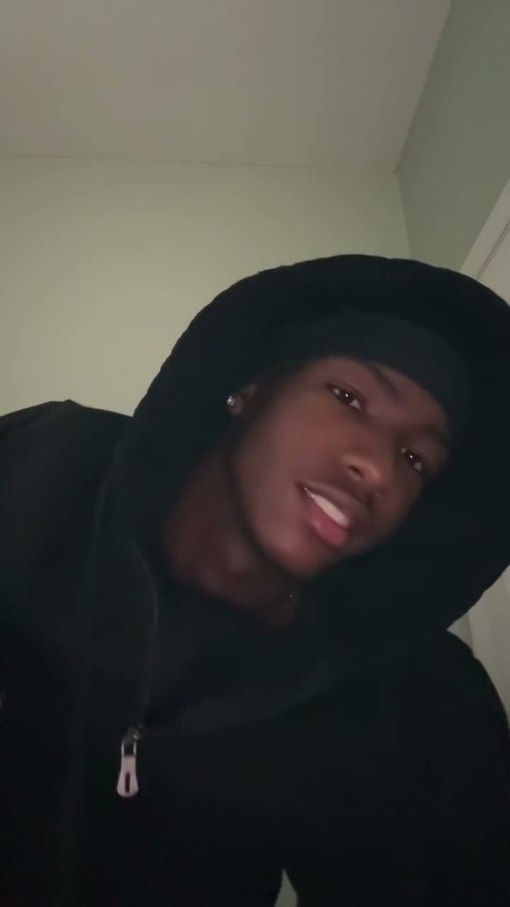 Skull cap trend: a guy pulls the skull cap on, then grins into a low-angle camera with his hood up