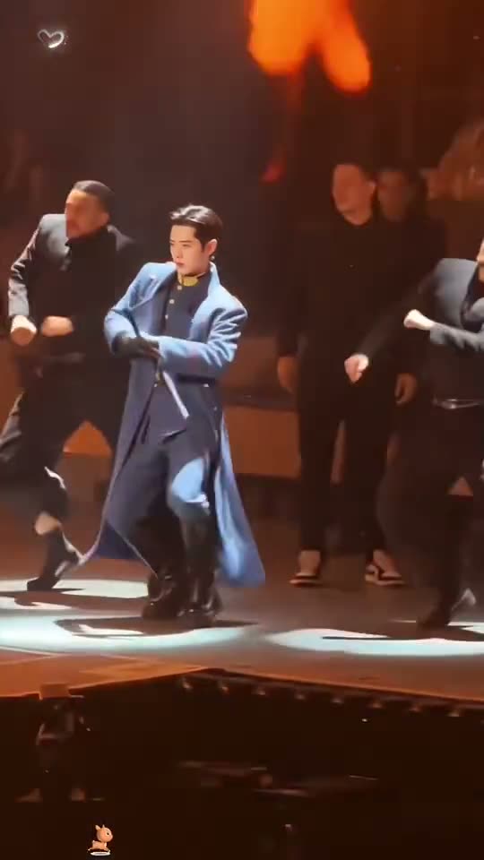 Talk Dirty dance AI: a man in a long blue coat walks out under the TALK DIRTY screen and leads the crew