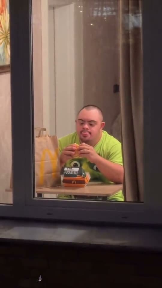 Window peeper AI: a man in a lime green shirt eats a burger at the window, with a green monster sitting beside him