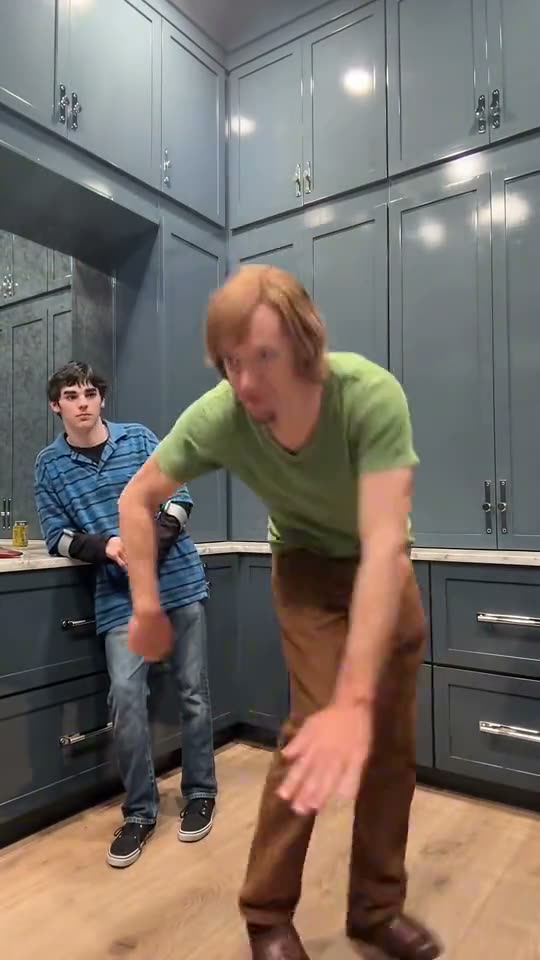 Wipe Me Down AI: a lanky character in a green shirt leads the Wipe Me Down dance in the kitchen with kids dancing behind